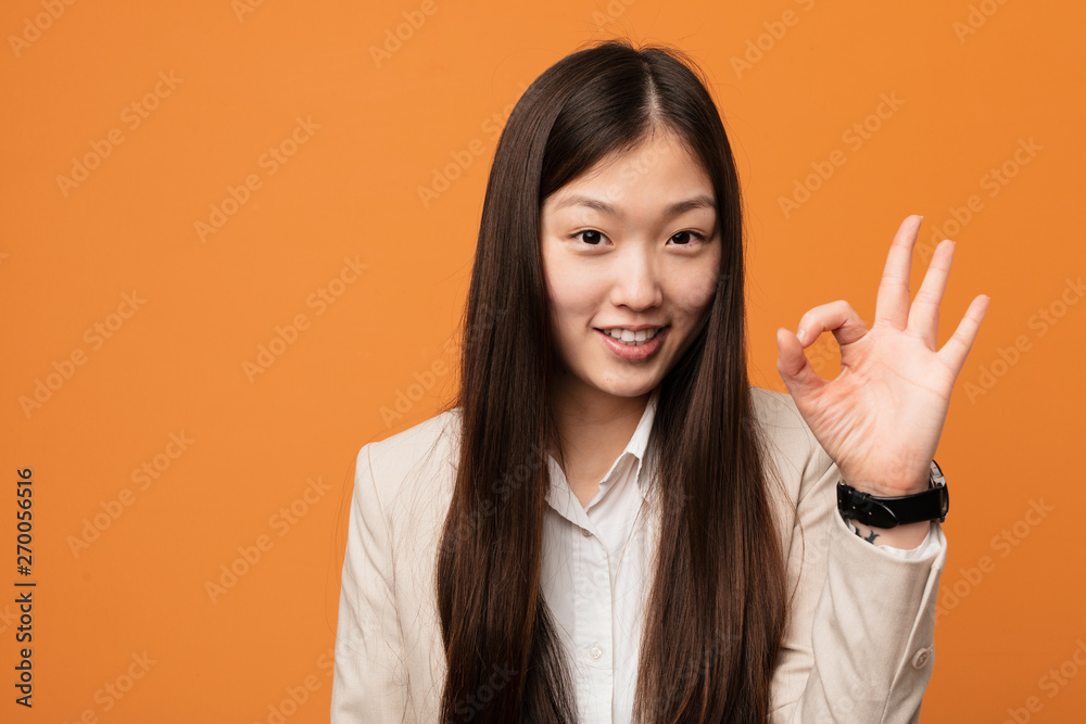 Young business chinese woman cheerful and confident showing ok gesture. Young business chinese woman cheerful and confident showing ok gesture.