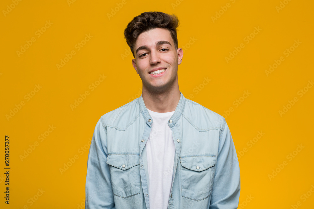 Obraz premium Young handsome student wearing a denim shirt happy, smiling and cheerful.