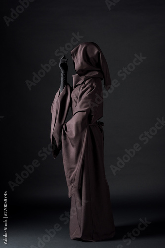 side view of woman in death costume on black