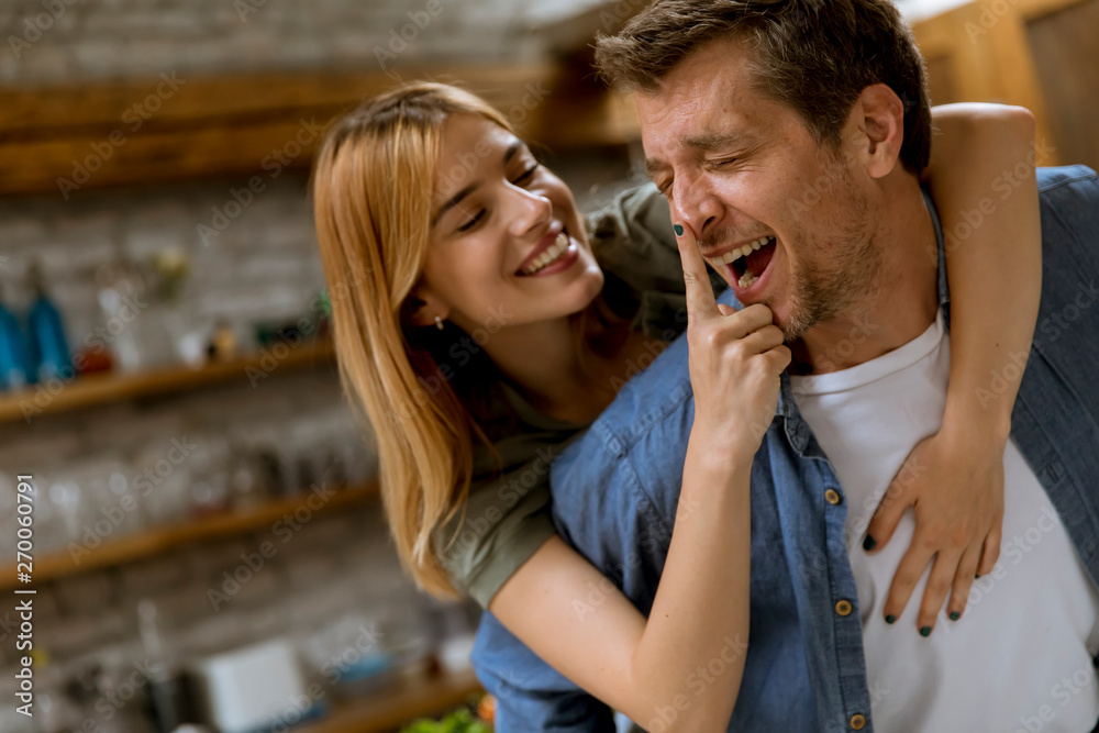 Lovely couple having fun together at rustic kitchen Lovely couple having fun together at rustic kitchen