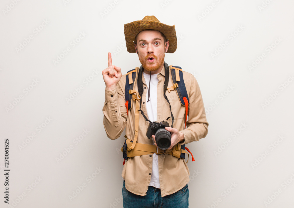 Young redhead explorer man having a great idea, concept of creativity. Holding a camera. Young redhead explorer man having a great idea, concept of creativity. Holding a camera.