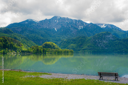 beautiful mountain scene with bench at a lake