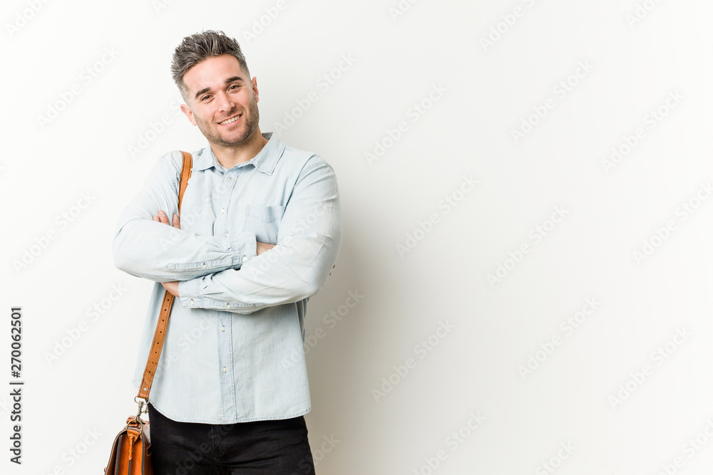 Young handsome business man who feels confident, crossing arms with determination. Young handsome business man who feels confident, crossing arms with determination.