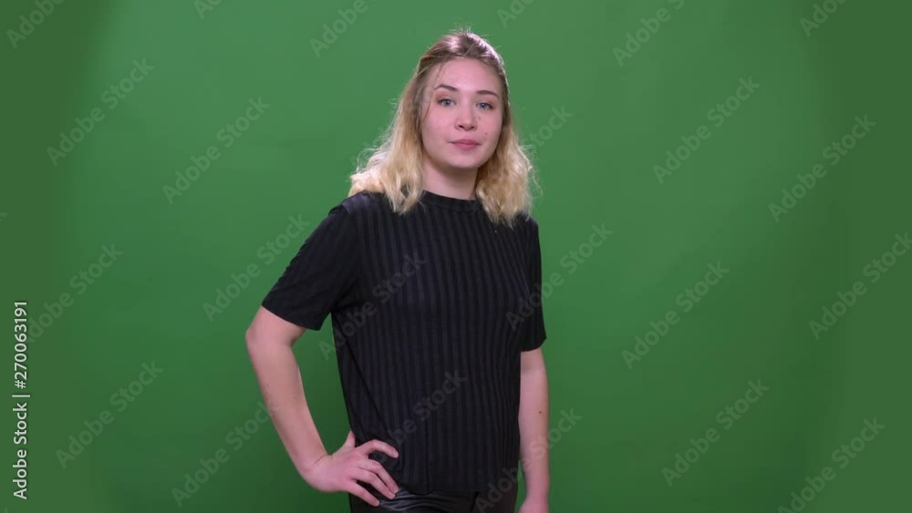 Closeup portrait of young pretty blonde caucasian female posing in front of the camera with background isolated on green Closeup portrait of young pretty blonde caucasian female posing in front of the camera with background isolated on green