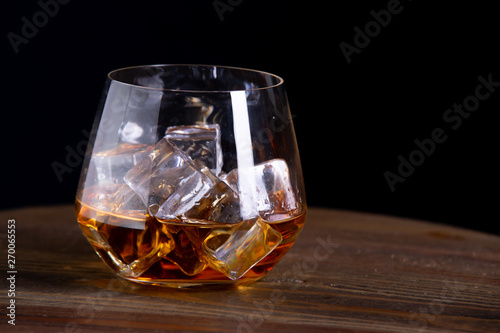 a glass of whiskey on wooden table
