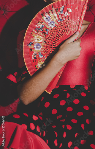 woman in red dress holding fan in hands