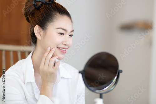 Portrait of a Beauty young woman brunette cosmetics looking in the mirror with fresh healthy facial skin,feeling so fresh and happiness,Beauty and Cosmetics Concept