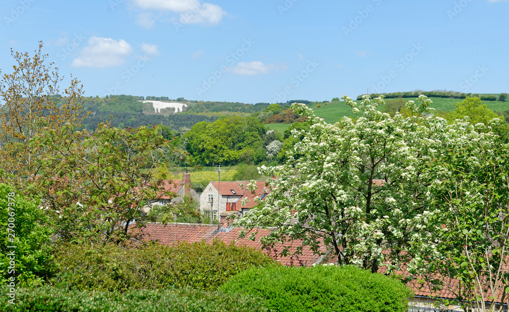 View across the rooftops of the iconic White Horse image on the hillside above the village of Kilburn in North Yorkshire, England