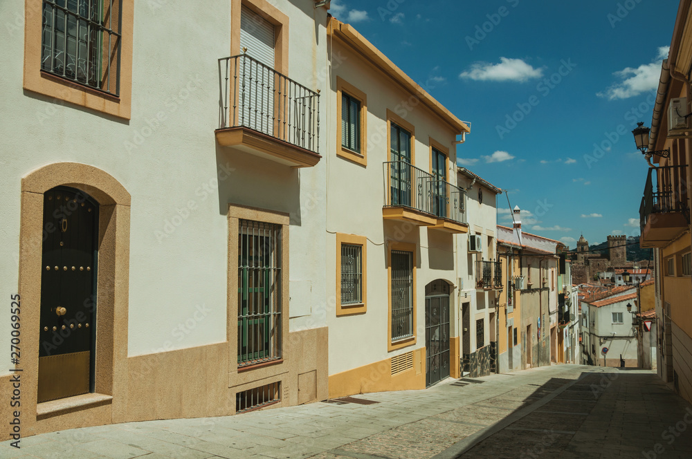 Deserted alley in slope and old buildings with terraces at Caceres
