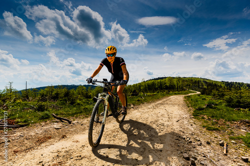 Mountain biking woman riding on bike in summer mountains forest landscape. Woman cycling MTB flow trail track. Outdoor sport activity. © Gorilla
