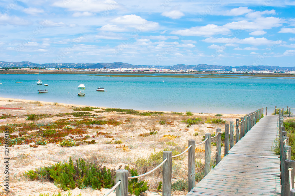 Praia De Faro, Algarve, Portugal. Aerial view on coast of ocean and beach. Boats on water, drone view 