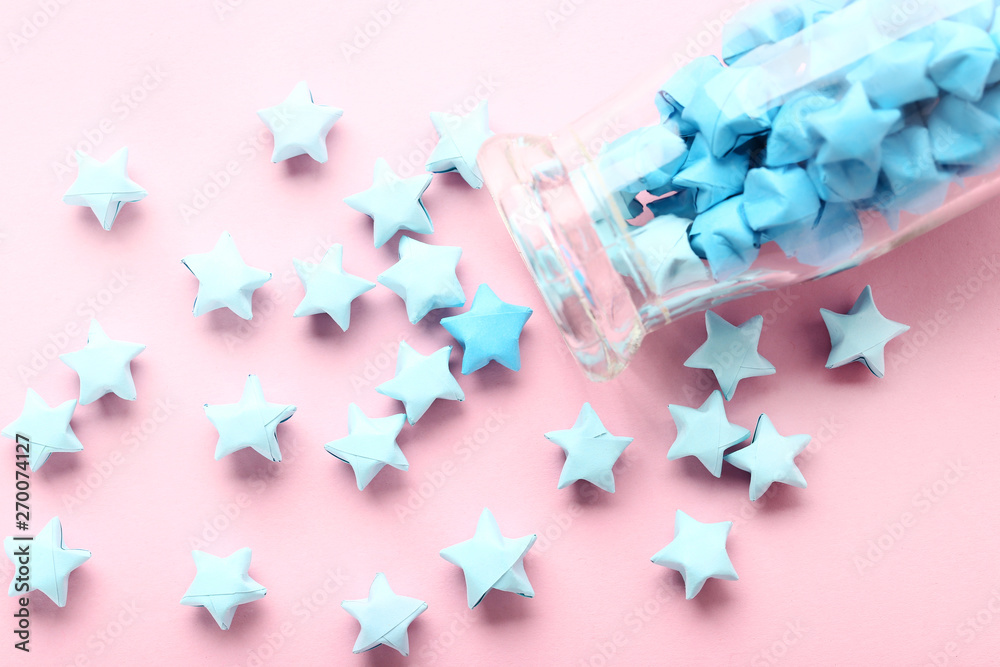 Blue paper stars with bottle on pink background