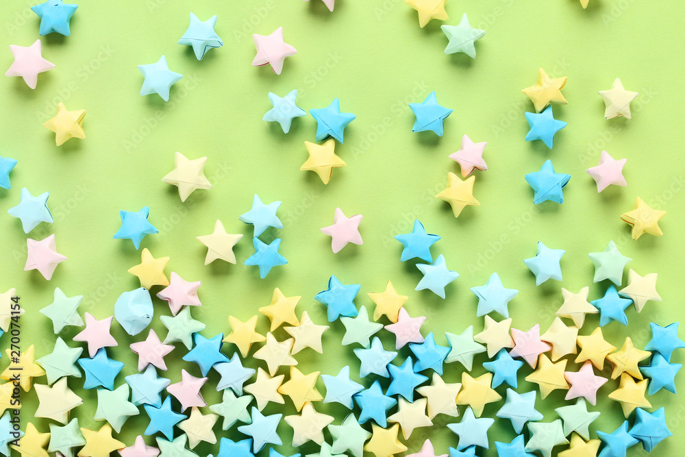 Colorful paper stars on green background