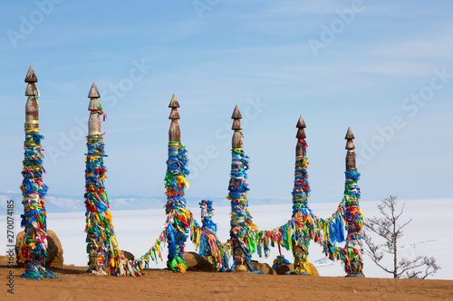 Wooden ritual pillars with colorful ribbons on cape Burkhan, Lake Baikal, Olkhon, Russia