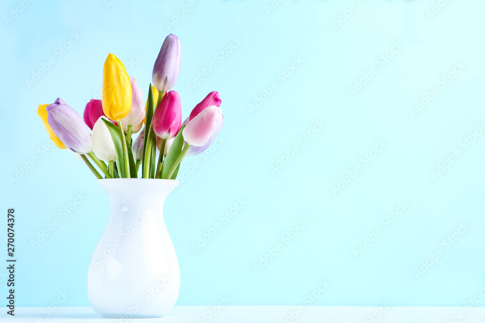 Bouquet of tulip flowers in vase on blue background Bouquet of tulip flowers in vase on blue background
