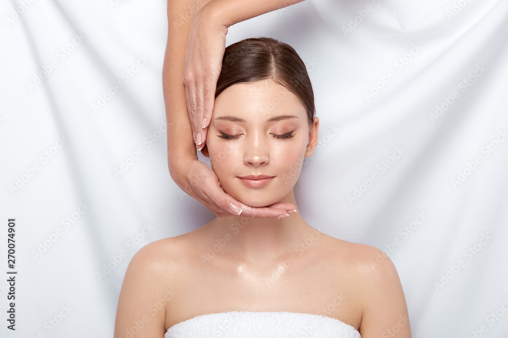 beautician doing facial massage for female customer