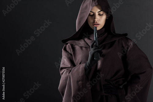 woman in death costume holding gun isolated on black