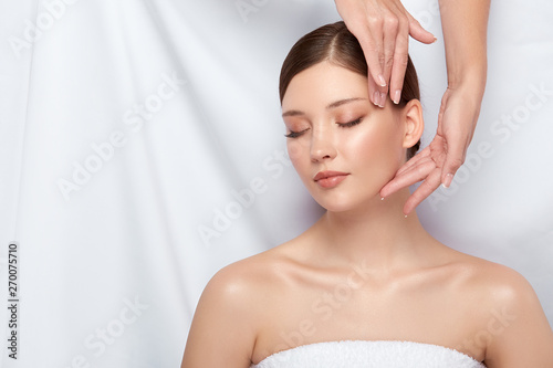 fresh woman face receiving skin treatment on white, female lying down and having beauty treatment, body relaxation