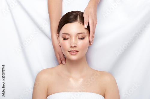 lovely girl receiving spa treatment on white, massage for face with beautiful woman, happy and healthy skincare customer