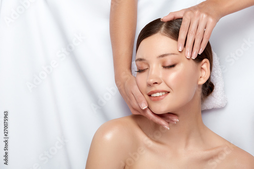 beautician's arms massaging woman's face on white, healthy skin care on beautiful girl, female on massage theraphy