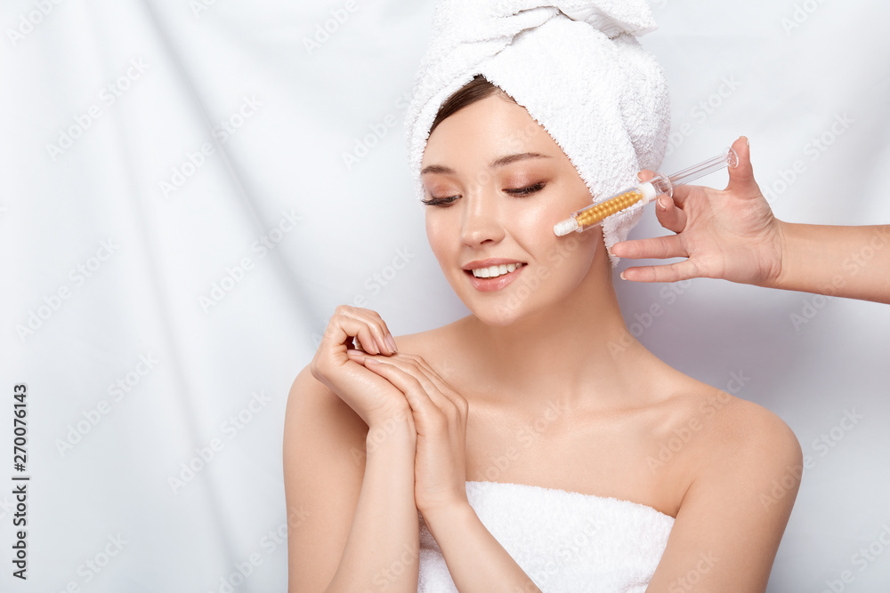 beautician holding syringe near woman's face in bath towel and open shoulders, woman getting beauty injection isolated on white beautician holding syringe near woman's face in bath towel and open shoulders, woman getting beauty injection isolated on white