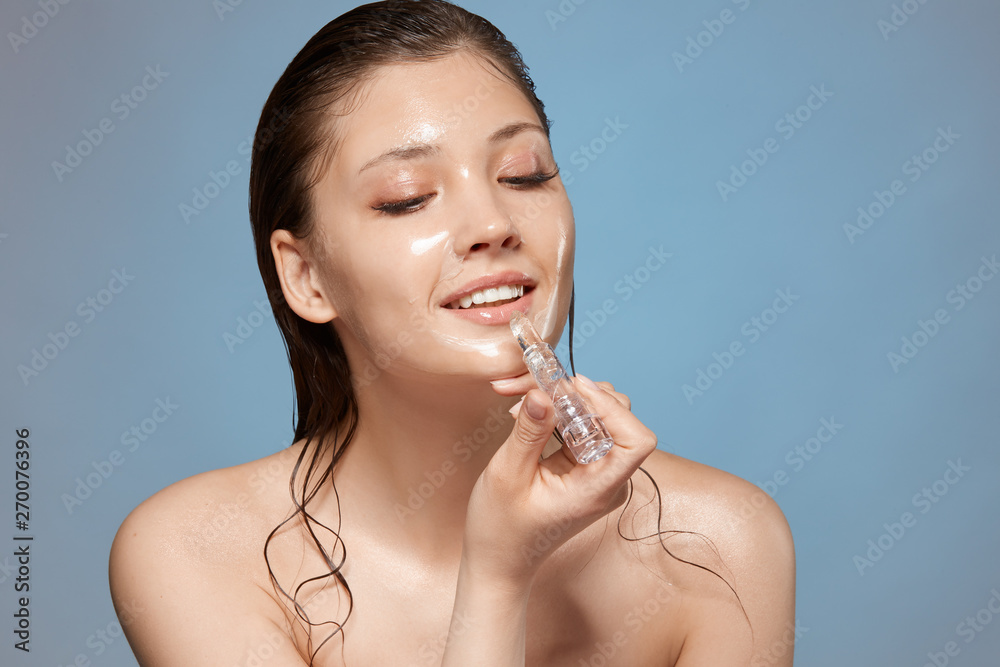 pretty girl with wet hair and nude make-up applying lipstick with smile on her face, copy space, fresh and beautiful facial treatment