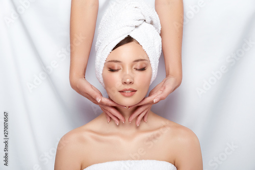 pretty woman in towel gets massage for her neck and face, fresh face receiving spa treatment, massaging and relaxation