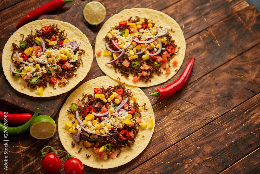 Healthy corn tortillas with grilled beef, fresh hot peppers, cheese, tomatoes