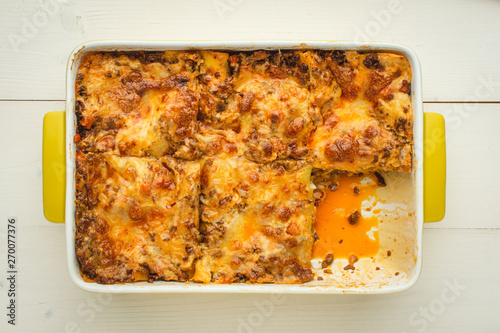 Italian Lasagna Bolognese with Beef, Cheese and Tomato Sauce on Rustic White Wooden Background