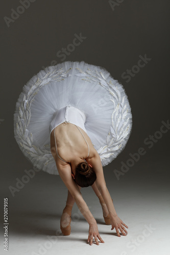 Obraz na plátně Young beautiful ballerina is posing in studio