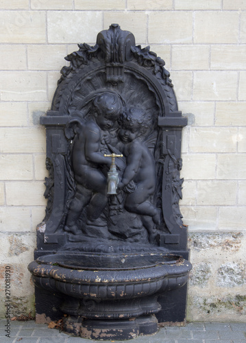 Street water pipe with sculpture of baby angels, Versal photo