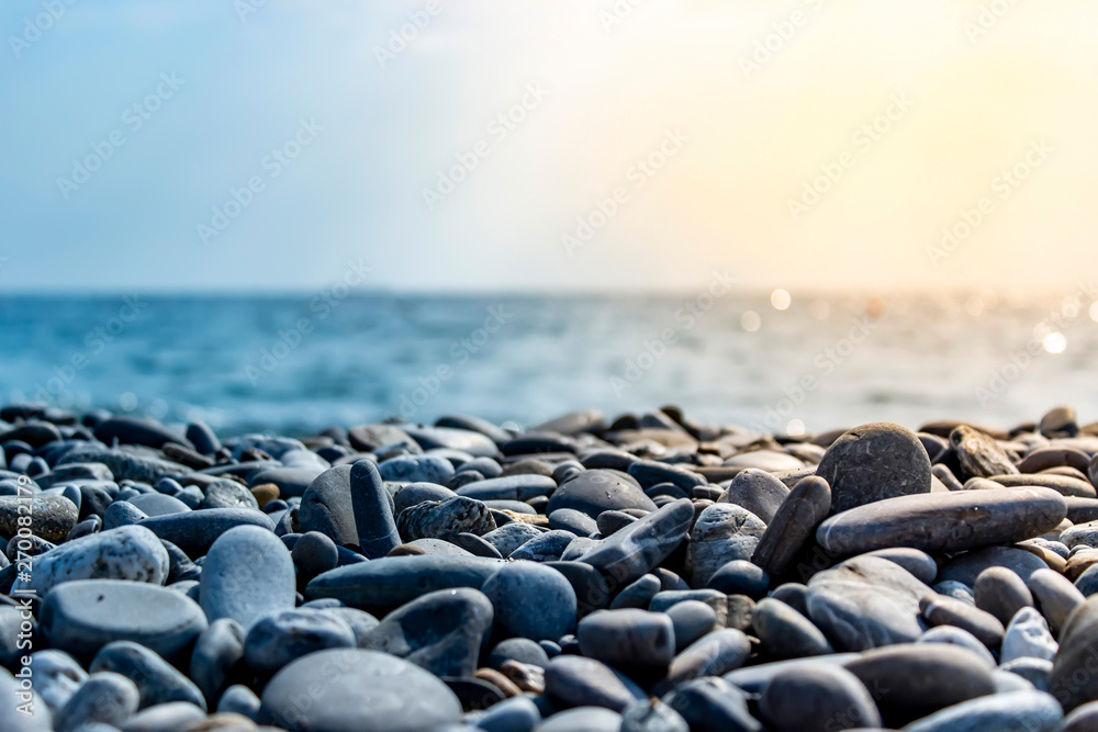 Sea stones and waves on the beach. Summer background. - obrazy, fototapety, plakaty 