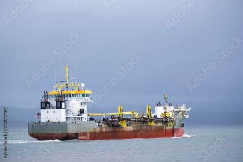 Cargo export container carrier ship vessel on sea under dark sky
