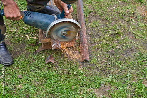 A man cuts a metal profile with a disk tool