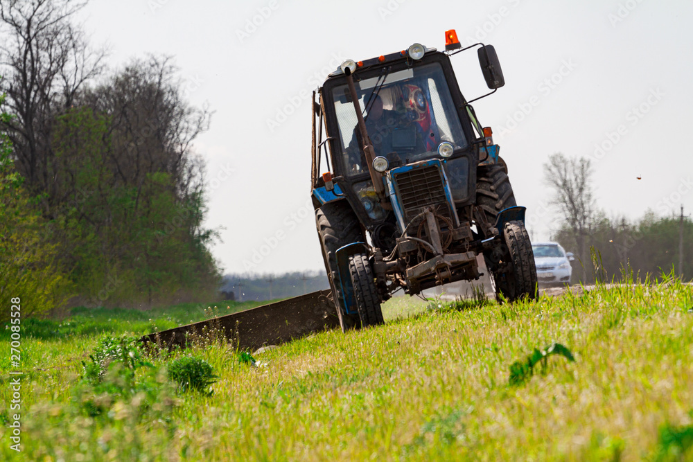 Tractor with a mechanical mower mowing grass Tractor with a mechanical mower mowing grass