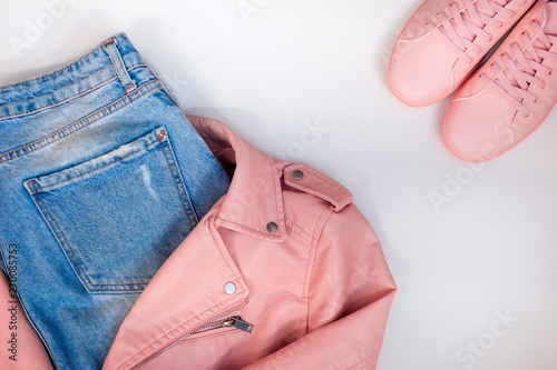 Flat composition with a set of clothes in pink colors. Top view of clothes on a white background.