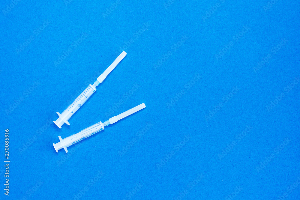 Disposable medical clean syringes on blue background