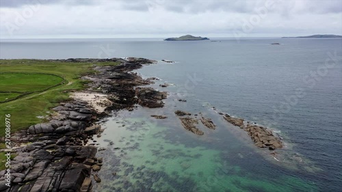 Drone flying over Irish coast with a calm blue Atlantic ocean