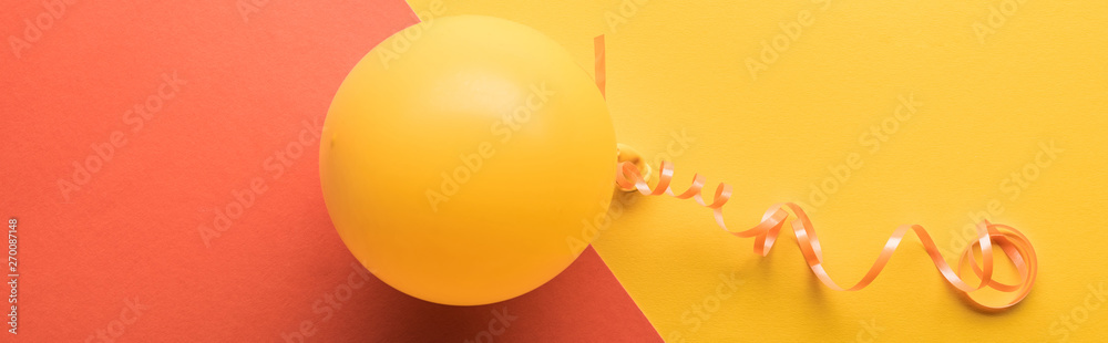 Panoramic shot of yellow balloon on coral and yellow background