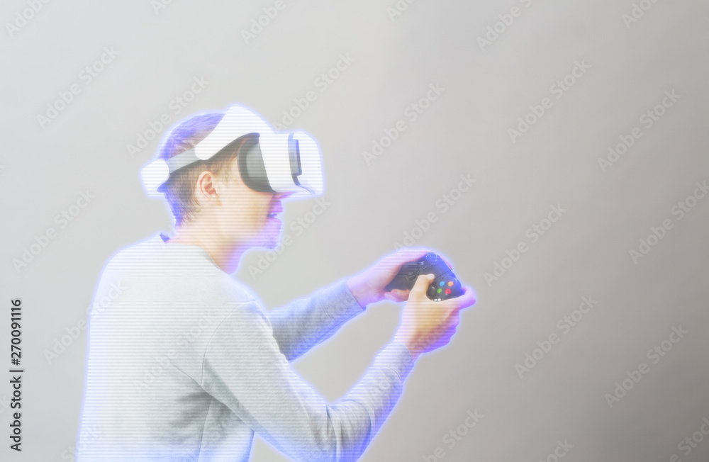 Man with virtual reality headset is playing game. Image with hologram effect. Man with virtual reality headset is playing game. Image with hologram effect.