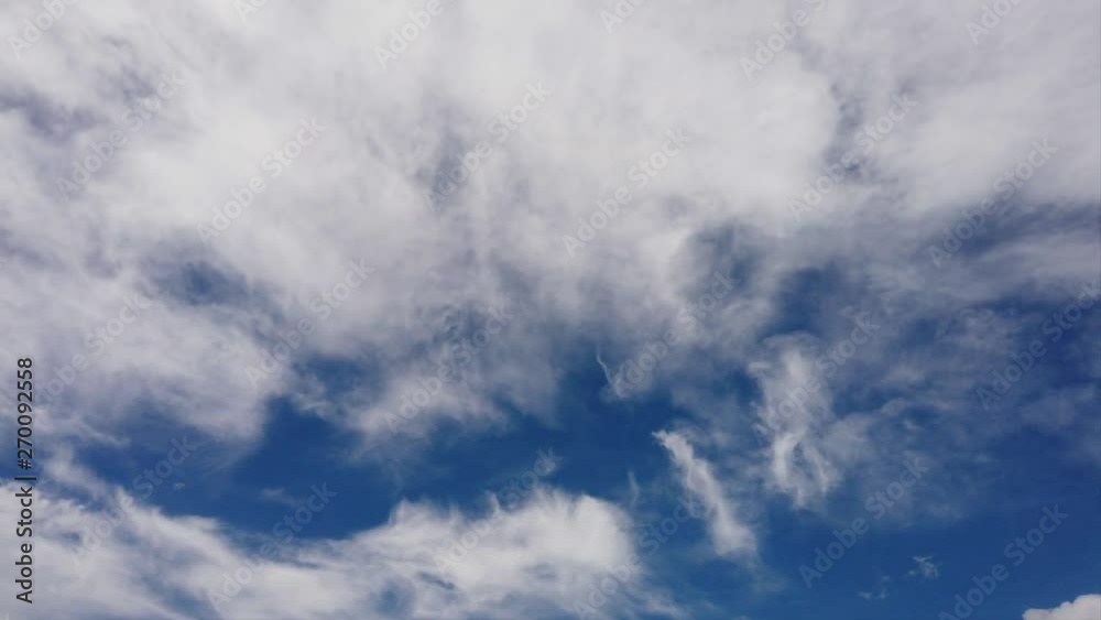Awesome timelapse of white fluffy clouds formations in a summer beautiful blue sky with light effects and evanescent movements Awesome timelapse of white fluffy clouds formations in a summer beautiful blue sky with light effects and evanescent movements