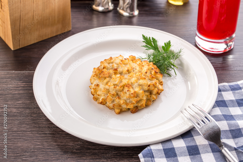 Fried pork chops in breadcrumbs on white plate on wooden table Fried pork chops in breadcrumbs on white plate on wooden table