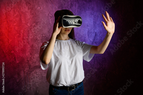 Young woman touching the air during the VR experience. Blue and red background