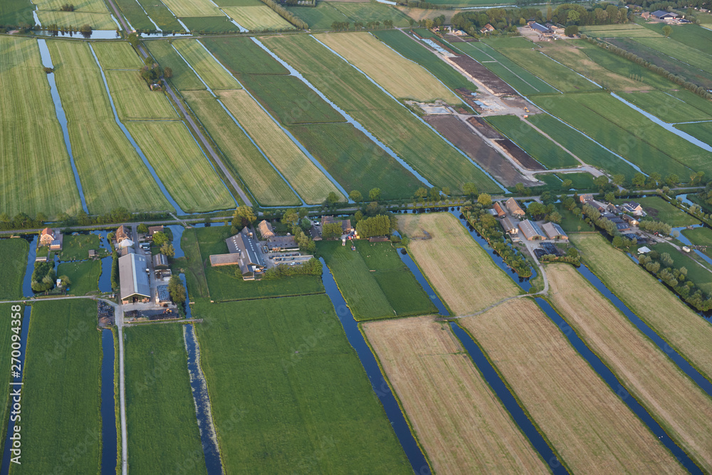Aerial of modern farms with solar panels on the roof in dutch meadow landscape