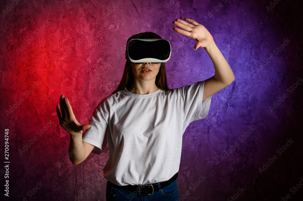 Young woman touching the air during the VR experience. Blue and red background