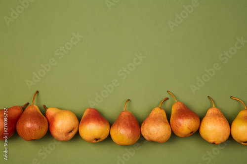 Colorful fruit pattern or background. Ripe fresh juicy pears placed on green background