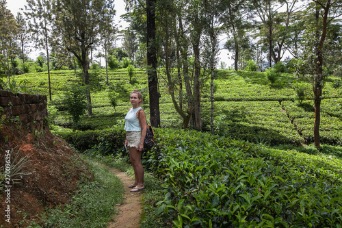 Cute female tourist exploring tropical tea plantation in Sri Lanka