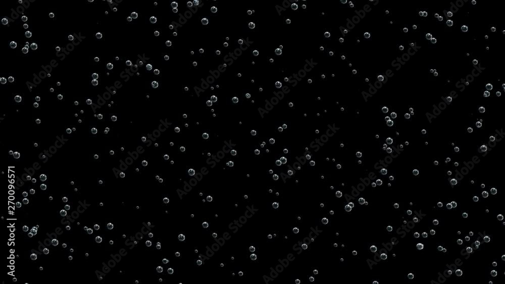 Bubbles of champagne are formed on the surface of the glass and slowly creep upwards on a black background. Bubbles of champagne are formed on the surface of the glass and slowly creep upwards on a black background.