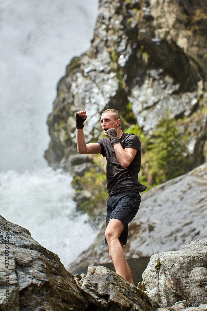 Muay thai fighter training by the waterfall