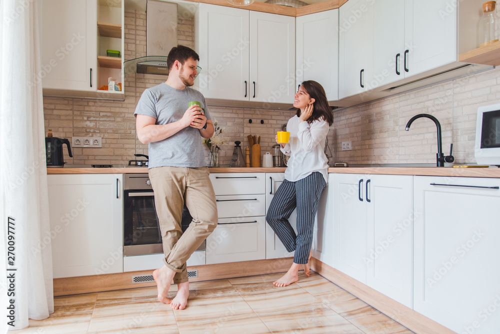 smiling man with woman at kitchen drinking tea smiling man with woman at kitchen drinking tea